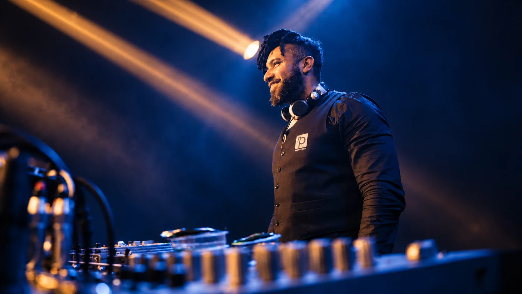 DJ com uniforme da RP Produções junto aos equipamentos de som e iluminação.